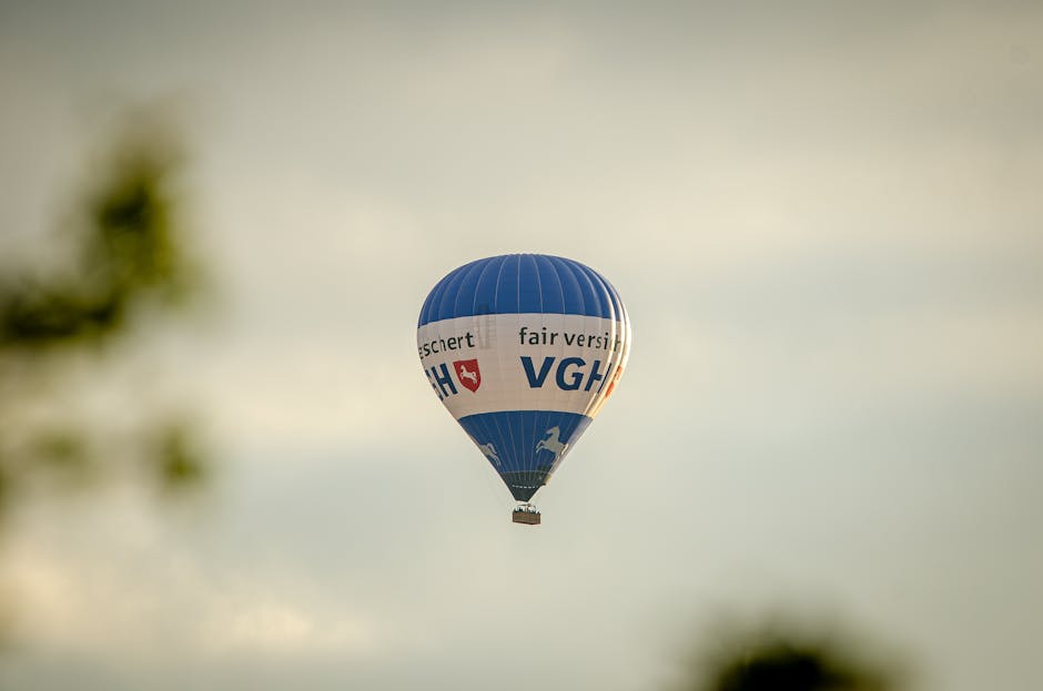 A blue hot air balloon with text flying in a clear sky, creating a serene travel scene.